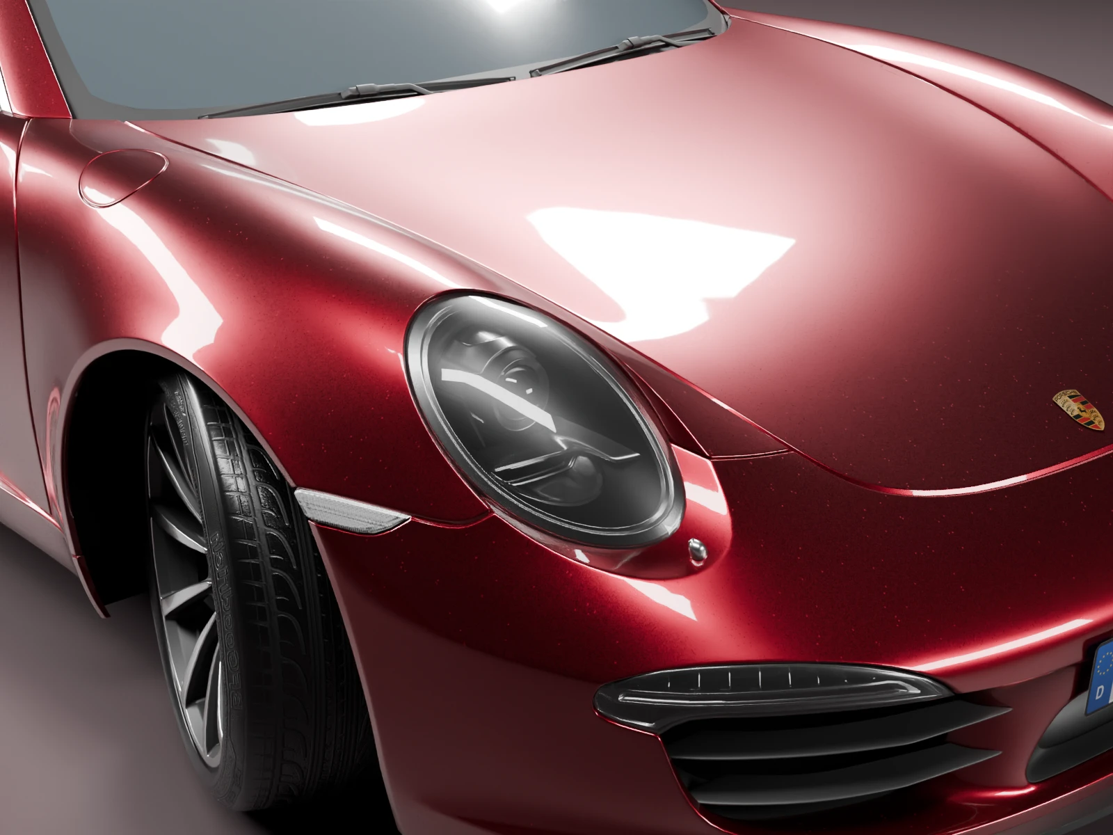 Close-up of the Porsche’s rounded headlamp and claret bodywork.
